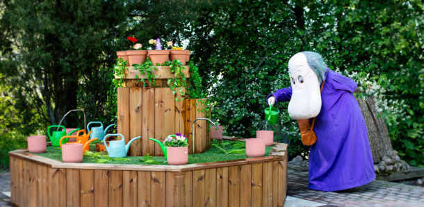 Hemuli kastelee kukkia kukkapenkissään.