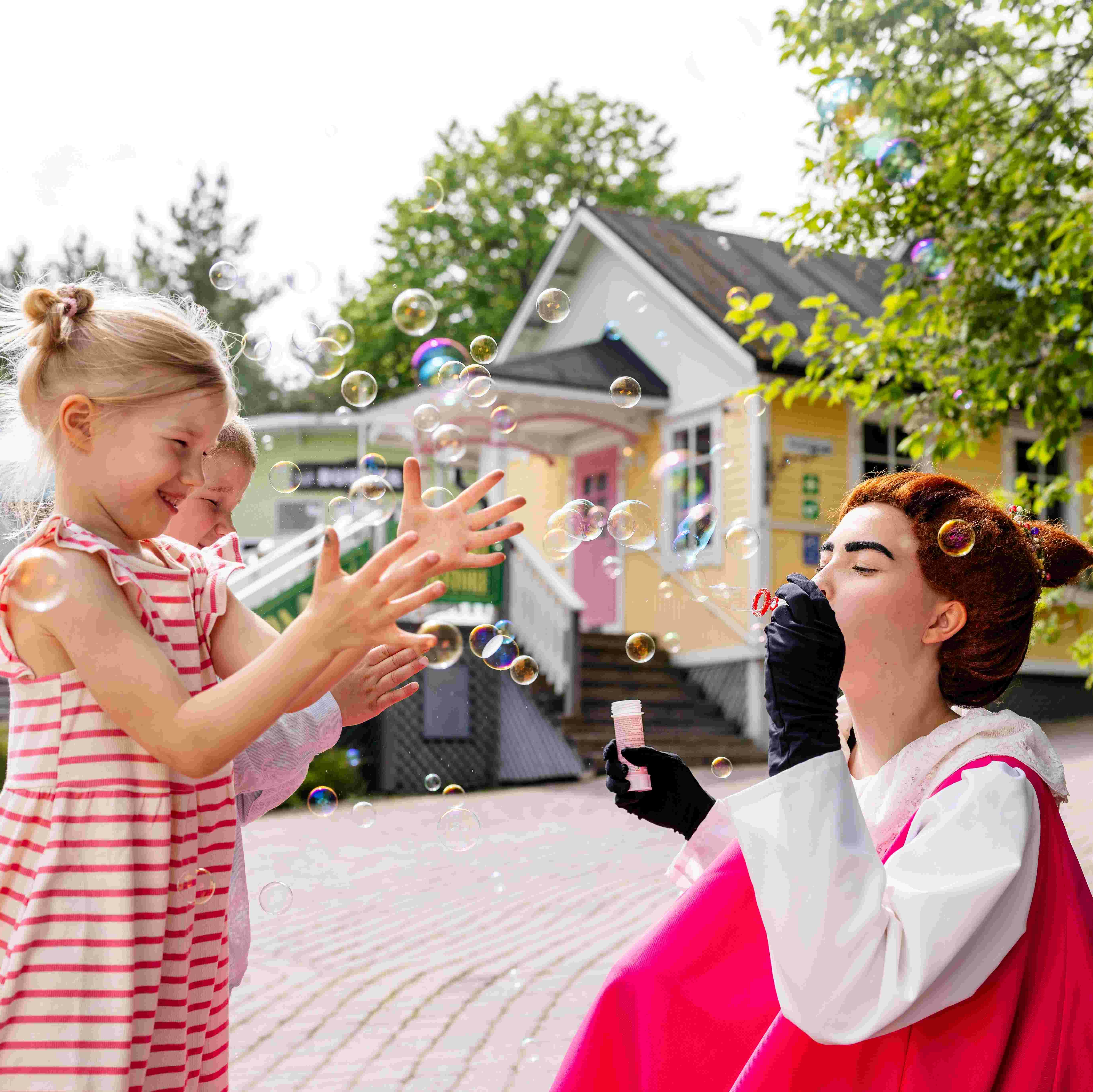 Barnen blåser såpbubblor med Mymble.