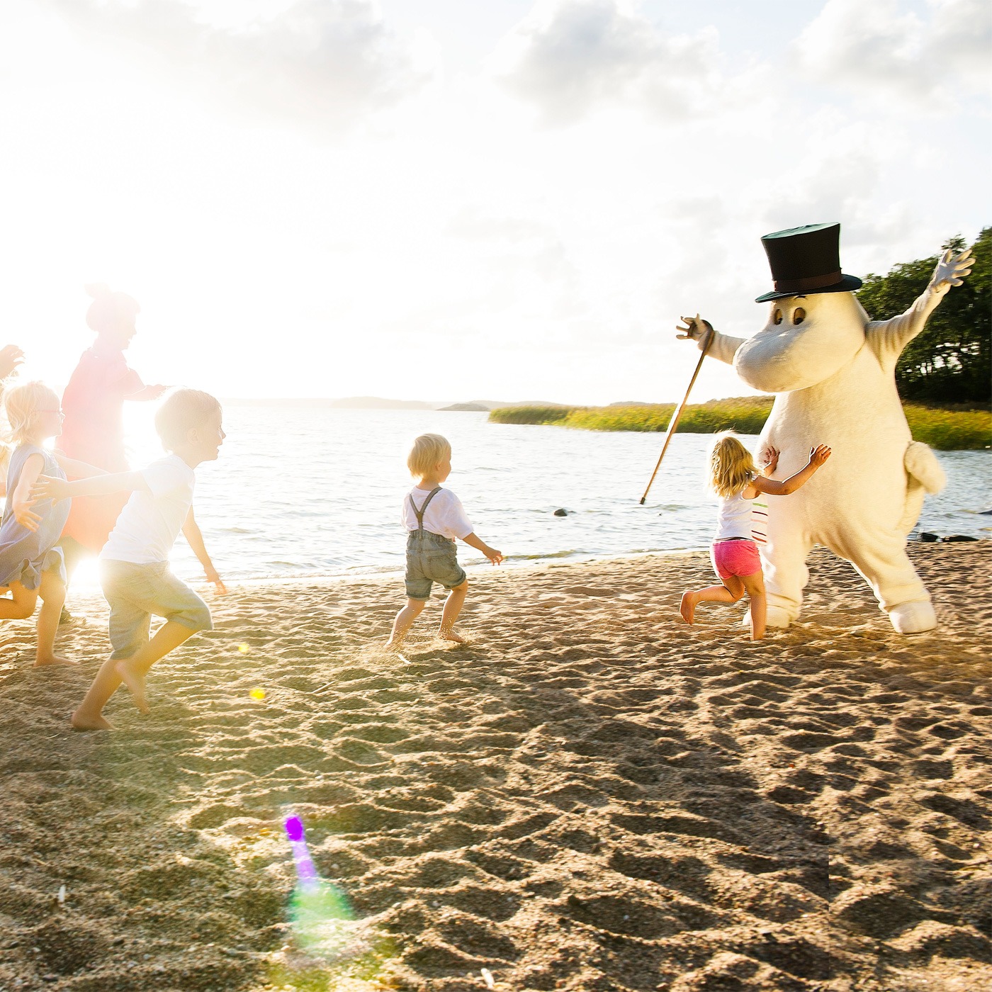 Muminpappa och barnen på stranden.